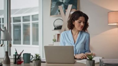 Dizüstü bilgisayarla çalışan çok görevli bir kadının notlarını yakından okuması. Profesyonel yönetici iş yerinde evrak işleriyle uğraşıyor. Çalışma alanındaki görevleri etkin bir şekilde yöneten meşgul kadın yönetici .