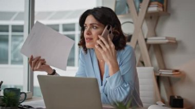 Stresli iş kadını lüks ofiste okuma raporunu arıyor. Ciddi bir iş kadını akıllı telefon oturma masasında iş problemini tartışıyor. Telefon görüşmelerindeki evraklarla ilgilenen kadın CEO..