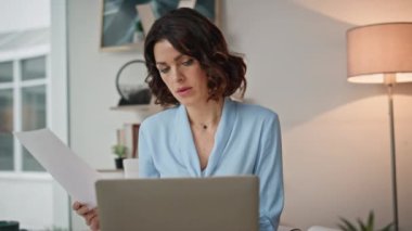 Modern ofis iç çekimlerinde kadın CEO analiz raporu. Ciddi bir bayan yönetici dizüstü bilgisayarla çalışan belgeleri okuyor. İşyerindeki iş belgelerini incelemekle meşgul bir girişimci. Proje kavramı