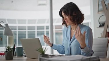 Yönetici projeyi bilgisayarla görüşüyor. Lüks ofiste oturuyor. Profesyonel danışman, kurumsal çalışma alanındaki online konferansta işi açıklıyor. Gülümseyen iş kadını web sohbeti