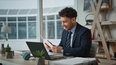 Dizüstü bilgisayarla yapılan mutlu finansal yönetici video görüşmeleri şirketin kâr raporunu kapatıyor. İnternetteki toplantıda gülümseyen yönetici konuşuyor. Neşeli CEO web konferansında başarıyı tartışıyor