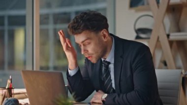 Hüsrana uğramış bir profesyonel, karanlık ofis masasında oturuyor ve stresi yakından gösteriyor. Tükenmiş yönetici dizüstü bilgisayarını geç saatte kapatıyor. Yorgun şirket çalışanı iş yerinde bunalmış hissediyor..