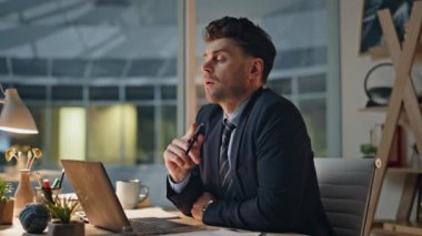Akşam müdürü dizüstü bilgisayarda internette sörf yapıyor modern şirket ofislerini kapatıyor. Lamba ışığında düşünceli iş adamı projesi. Ciddi çalışan planlama stratejisi geliştirme üzerine düşünüyor.