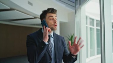 Endişeli girişimci cep telefonu konuşmasından yakınıyor endişeli iş sorunları kapanıyor. Sinirli iş adamı akıllı telefon ofis koridorunda konuşuyor. Tatminsiz yönetici iş krizini tartışıyor