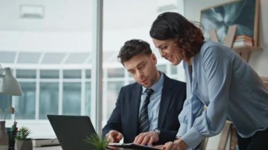 İki iş arkadaşı ofiste beş başarılı iş anlaşması yapıyor. Kapanış. Gülümseyen iş kadını neşeli iş adamına mali rapor veriyor. İş ortakları iş başarısına duygusal tepki veriyor.