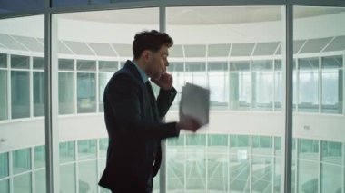 Ofis penceresinin yanında telefonla bağıran duygusal patron. Akıllı telefon görüşmesinde bağıran öfkeli bir yönetici şirket koridorunda kağıtları fırlatıyor. Kızgın işadamı kötü haberden şikayetçi.