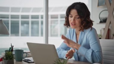 Bilgisayarda el kol hareketi yapan iş kadını web kamerasında yakın plandaki işi açıklıyor. Profesyonel danışman video, masa başında projeyi tartışıyor. İş yerindeki internet toplantısında konuşan akıllı iş kadını.