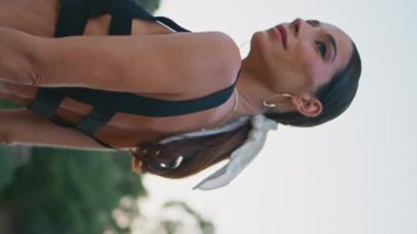 Moda kızı sokak parkında dikey çekimle baş başa geçireceği yaz akşamının keyfini çıkarıyor. Şık, rahat bir kadın şehirde poz veriyor. Etrafa bakıyor. Haftasonu gülümseyen sakin bayan dinleniyor. Kamera hareket ediyor.