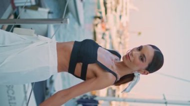 Mutlu kız rıhtımda dikey olarak demirli beyaz yatların önünde dinleniyor. Hafta sonu lüks tekneleri olan zarif bir kadın turist. Rıhtımda gülümseyen kameraya poz veren tasasız bir model.