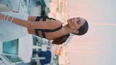 Huzurlu kadın, lüks beyaz yatlarıyla rıhtımda güneşli bir gece dikey meleğiyle düşünüyor. Mutlu stil düşkünü gezgin kız tek başına setin kenarında dikiliyor. Yazın teknelerin yanında bronzlaşmış kadın poz veriyor..