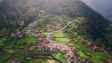 Küçük dağlar kasabanın hava manzarası. Yazın güneş ışığı altında kırmızı çatıları olan görkemli kırsal alan. Yol kıvrımlı yemyeşil tepeler. İHA, Madeira Portekiz 'in sakin kırsal atmosferi.