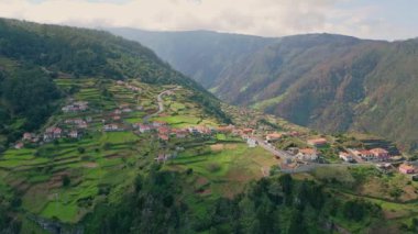 Dron yeşil dağ yamacı evleri. Tepe tepe arazi panoramik manzara manzarası. Yaz güneşinin uzak kırsal kesimlerinde. Resimli dağlık bölgelere yerleştirilmiş güzel kırmızı kiremitli evler