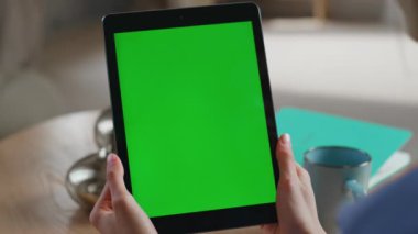Çevrimiçi öğrenci evdeki kapalı mekanda yeşil ekran tableti izliyor. Modern ofisteki bilinmeyen kadın elleri krom bir bilgisayarı tutuyor. İş kadını web sitesini tarıyor Mockup dijital aygıtında.
