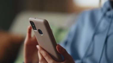 Ergen eller cep telefonunun dokunmatik ekranını yakın çekimde kaydırıyor. Kanepede oturmuş akıllı telefon mesajı okuyan gülümseyen kadın. Dairedeki kanepede cep telefonundan haber izleyen çekici bir kız..