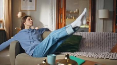 Kanepe dairesinde uzanan rahat ve mutlu bir kadın. Oturma odasında sakin vakit geçiren genç bir kadın. Çekici kız, hafta sonu evde tek başına rahat bir kanepede dinleniyor..