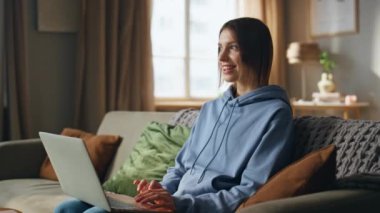 Dizüstü bilgisayarda çalışan, rahat kanepe kapanışı yapan pozitif serbest yazar. Gülümseyen kadın yazar evdeki kanepede bilgisayarda yazı yazmak için ilham kaynağı oldu. İnternette sohbet eden mutlu kadın uzaktan iletişimin keyfini çıkarıyor.