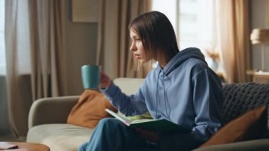 Evde kanepede oturup kahve içmeye odaklanmış bir öğrenci. Ciddi kadın deftere not alıyor. İnternetten bilgisayardan Webinar dinliyor. Rahat genç kız kanepede dizüstü bilgisayarla eğitim videosu izliyor..