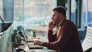 Yorgun işçi, modern ofiste cep telefonunu kapatır. Profesyonel yönetici iş yerindeki akıllı telefon konuşmasından sonra yorgun hissediyor. Tükenmiş iş adamı dizüstü bilgisayar görünümlü telefon konuşmasını bitiriyor.