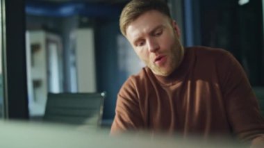 Öfkeli işadamı video konferansına bağırıyor ve belgeleri yakın çekimde tutuyor. Kızgın patron çevrimiçi konferansta evrak işlerini tartışıyor. Tatminsiz yönetici dizüstü bilgisayarı kapatıyor internet çağrısını bitir.