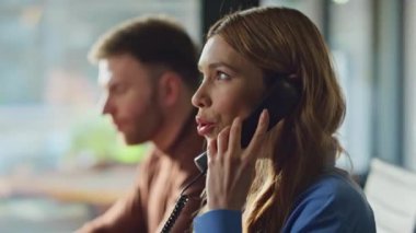 Telepazarlama uzmanları birlikte çalışma alanındaki telefonu arıyorlar. Ofisteki sabit hatlı telefondan müşterilerle konuşan destek servisi çalışanları. İki telesale yöneticisi müşterilere uzaktan danışıyor..
