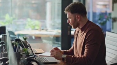 Modern kurumsal iç mekanda dizüstü bilgisayar işine odaklanan meşgul bir çalışan. Ciddi iş adamları ofis masasında dokümanları okurken memnuniyetsiz hissediyorlar. Sinirli yönetici mali raporu analiz ediyor.