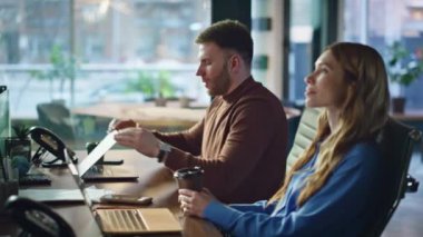 İş arkadaşları yoğun iş günlerinden sonra bilgisayarları kapattıktan sonra kahve molası veriyorlar. Modern işyerinde iş birliği yapan meslektaşlar dostça sohbetin tadını çıkarıyorlar. İki çalışan içecek servisi yapıyor.