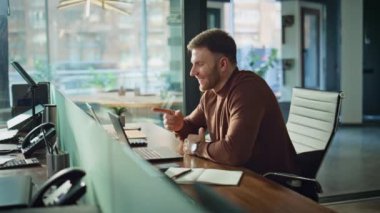 Modern ofis içi bilgisayardan gülümseyen çalışan videosu. Olumlu iş adamı çevrimiçi konuşuyor ve görevleri uzaktan tartışıyor. Neşeli yönetici bilgisayar kamerasına el sallıyor.