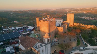 Kırmızı kiremitli çatı panoramik hava manzaralı köy manzaralı kale kuleleri. Eski Portekiz şehrinde taş tarihi duvarları olan ortaçağ mimarisi. Manzaralı ortaçağ yerleşiminde akşam.