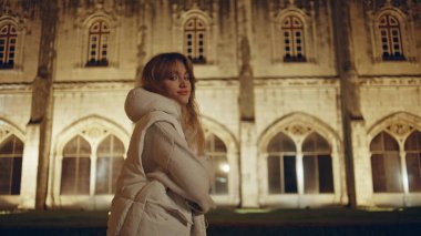Neşeli kadın gece vakti tarihi binaları keşfediyor. Katedral ışıklarıyla aydınlatılmış alanda gezen kaygısız bir kız. Görkemli mimarinin yanında turist gezintisi kutlu olsun..