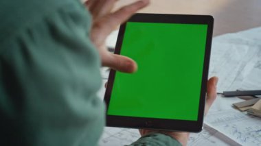 Tasarım stüdyosunun iş yerinde parmakları yakınlaştırma tableti. Çevrimiçi uygulamalar için yeşil ekran bilgisayarında çalışan kimliği belirsiz bir erkek serbest yazar. Krom anahtar dijital aygıta sahip bir işadamı.