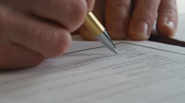 Yönetim kurulu başkanı, masa başı iş yerinde yakın çekim için belge imzalıyor. Ofisteki iş toplantısından sonra bilinmeyen bir işadamı evrakları yazıyor. Yönetici sözleşme imzaladı. Anlaşma sigortası yaptırdı..