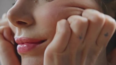 Güzel bir bayan kapalı alanda tenine dokunuyor. Bilinmeyen kadın hafif banyoda yüz masajı yapıyor. Odaklanmış model evde jimnastik egzersizleri yapıyor. Ev konseptinde güzellik hizmetleri