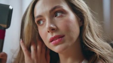 Kapalı alanda gülümseyen saçları kurutan pozitif model. Evinde Chevelure tarzı fırçalayan hoş bir kız. Açık banyoda kurutma makinesi kullanan güzel bir kadın. Bayan güzellik rutin konsepti 