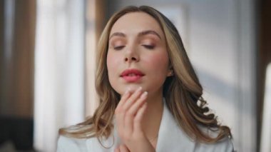 Tuvalette aynaya bakan güzel kadın. Derisini inceleyen mutlu, sakin bir kadın. Sıcak apartman dairesinde tek başına yansımasının keyfini çıkarıyor. Sabah banyo odasında poz veren memnun model fotoğraf makinesi.