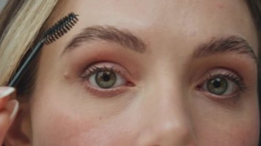 Pov denen kadın evde kaşlarını fırçalıyor. Tanımlanamayan yeşil gözlü kız yüzü fırça aletini kullanarak makyaj hazırlıyor. Anonim model özel jel uyguluyor. Sabah evde hazırlanıyor.