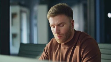 İş yerindeki cep telefonuna benzeyen çalışkan, mutlu edici bir iş başarısı. Mutlu iş adamı, akıllı telefonları ofis masasında tutmaktan mutlu. Duygusal adam gülümsüyor.