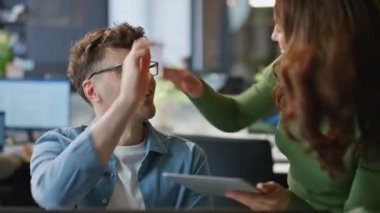 Buro acentesinde başarılı görünen bilgisayarı kutlayan mutlu ofis çifti. Neşeli meslektaşlar kabinede beşlik çakıyor. Kurumsal işyerinde birlikte çalışan heyecanlı kadın kazananlar.