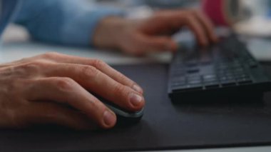 Adam şirket ofisinde bilgisayarı parmaklıyor. Çalışan adam makro görüntüde tuşlara basıyor. Uzak işyerindeki klavyede çalışan modern aygıtı kullanan tanınamayan serbest çalışan 
