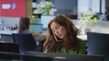 Çağdaş iş yerinde cep telefonu müşterisiyle konuşan meşgul bir iş kadını. Başarılı bankacı kadın, şirket ofisinde iş görüşmesi yapıyor. Tek başına profesyonel danışmanlık yapıyor.