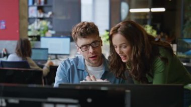 Neşeli ekip ofiste birlikte çalışıyor. Tablet bilgisayar ekranını yakından inceliyorlar. Mutlu gülümseyen meslektaşlar zafer kazandıkları için heyecanlı hissediyorlar. Gülen iş çifti beşlik çakıyor.