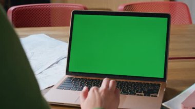 Çalışan, uzak iş yerindeki bilgisayarda yeşil ekran dokunmatik dokunmatik dokuyu kullanıyor. Ofiste tanınmayan bir iş kadını dizüstü bilgisayara dokunuyor. Masadaki Chromakey Dijital Alet 'te çalışan bilinmeyen bir kadın.