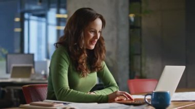 Laptop ekranında harika haberler okuyan heyecanlı kadın lüks ofisin kapanışında oturuyor. Genç iş kadını müdürü iş hayatında elde ettiği başarıyı sevinçle dile getiriyor. Çalışma başarı konsepti