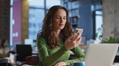 Ofisteki bayan iyi haberlerle yakın çekimle mesaj aldı. Mutlu gülümseyen menajer cep telefonu mesajları atıyor. Bilgisayarda çalışan duygusal iş kadını akıllı telefon bildirimi okuyor. Kariyer tanıtımı başarılı 