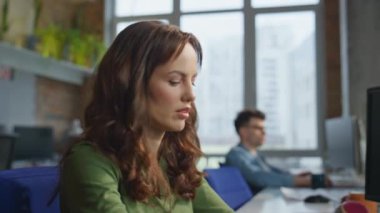 Ofiste klavye çalan düşünceli bir bayan. Rahatlamış gülümseyen iş kadını görüntüsü modern masada yoğunlaşmış hissediyor. Mutlu kadın yönetici iş yerinde masaüstüne bakıyor