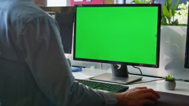 Modern iş yerinde yeşil ekran bilgisayarda çalışan tanınmamış bir serbest çalışan. Tanınmayan iş adamı Chroma Key masaüstü monitörü internette geziniyor. Ofis çalışanı web sitesi tasarım bilgisayarı