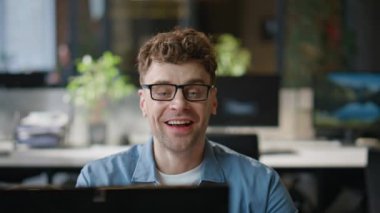 Yaratıcı yönetici modern ofiste görüntülü konuşma istiyor. Neşeli iş adamı ortağıyla sanal görüşme yapıyor. Tıraşsız gülümseyen adam şirket işyerinde online konuşma laptopu danışmanı 