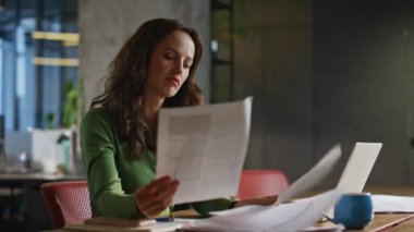 Modern ofis masasında oturan evrakları inceleyen bir acemi. İşyerindeki dizüstü bilgisayarlarda çalışan kadın yöneticilere bakıyorum. Kafa tutan kafası karışmış bir kadın. Kurucu iş hatası.