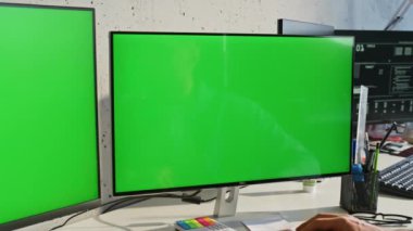 İki model monitör açık ofis masasının dışına yerleştirildi. Bilgi işlemci, çalışma odasındaki yeşil ekranlı bilgisayarda çalışıyor. Modern veritabanı merkezinde arama yapan ciddi programcı teknisyeni videosu
