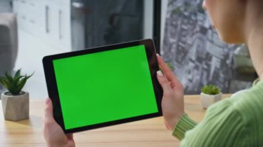 İş kadını videosu, aydınlık ofisteki tableti çağırıyor. Yatay yeşil ekran ped aygıtı kullanan tanınmayan girişimci. Modern evdeki kadın elleri krom anahtar sekmeli bilgisayarı tutuyor