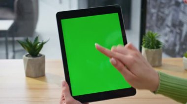 İş yerinde yeşil ekran tableti kullanarak internet sörfü yapan yönetici parmağı. Ofisteki dokunmatik ekrana dokunan kromakey ped bilgisayarı tutan kadın elleri. Model sekme aygıtı üzerinde çalışan iş kadını